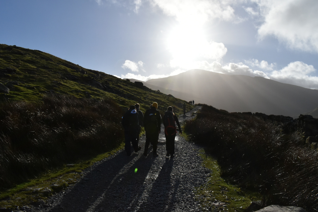 Photo of 2nd/9th Ruislip Scouts walking up Snowdon. The sun is just above the peak of Snowdon